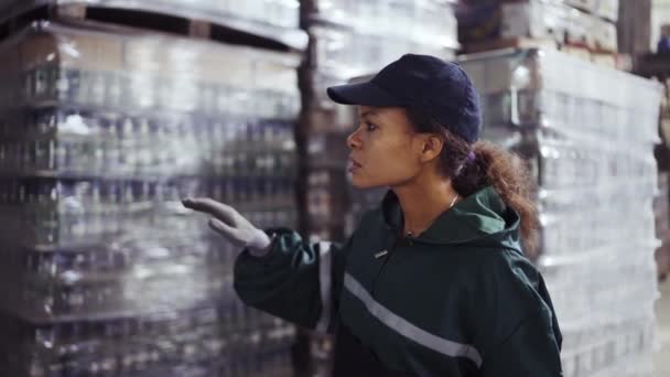 特殊な緑色の制服を着たアフリカ系アメリカ人女性の肖像画は廃棄物リサイクル工場の箱を数えます 工場の背景 原料の処理 リサイクル 公害防止 — ストック動画