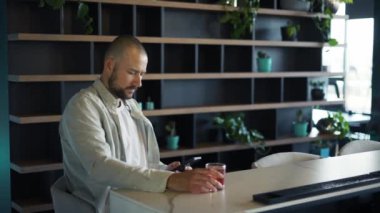 Mutlu sakallı adam cep telefonu ekranına bakıyor ve gülümsüyor..