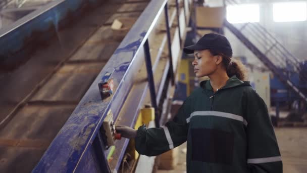 Ung Afrikansk Amerikansk Kvinna Kontrollerar Transportband Med Tryckknappar Avfallsåtervinningsanläggningen Föroreningskontroll — Stockvideo