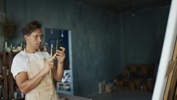 Jovem Artista Feliz Óculos Com Telefone Nas Mãos Desenha Tira — Vídeo de Stock