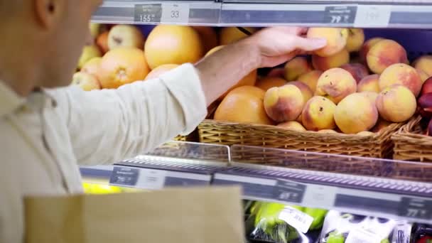 Návštěvník Obchodu Středního Věku Vybírá Broskve Vitríny Dává Papírového Sáčku — Stock video