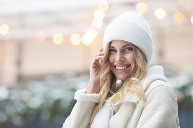 Açık havada gülümseyen kışın giydiği güzel ve mutlu genç bir kadının portresi.