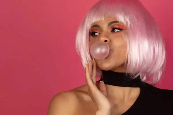 セクシーな若いですアフリカ系アメリカ人女性とともに鮮やかなメイクアップインフレーションAバブルのガムでピンクの背景 — ストック写真
