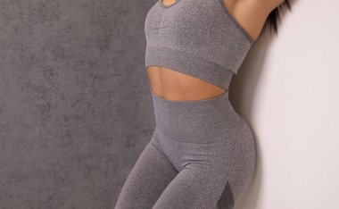 Stüdyoda spor kıyafetli çekici bir kadının orta bölümü.