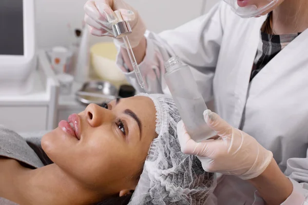 Cosmetologist Gotejando Soro Cosmético Uma Cara Mulher Durante Procedimento Beleza — Fotografia de Stock