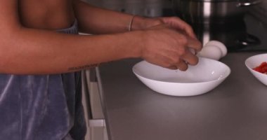 Yumurtayı kaseye kıran kadın yumurta sarısı olduğunu gösteriyor. Mutfakta yemek yapmak için. Ev yapımı ve ev yapımı yemek konsepti.