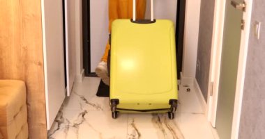 Sarı bavul taşıyan adamın kırpılmış görüntüsü, seyahat konsepti.