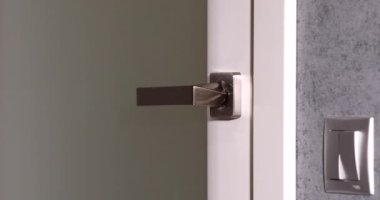 Erkek el ele tutuşup kapıyı açarken yakın plan görüntüsü.