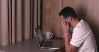 İlaçları alan ve dizüstü bilgisayarla çalışan yorgun genç adamın yan görüntüsü 