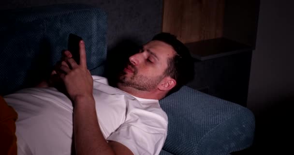 Joven Guapo Usando Teléfono Inteligente Durmiendo Mientras Está Acostado Sofá — Vídeos de Stock