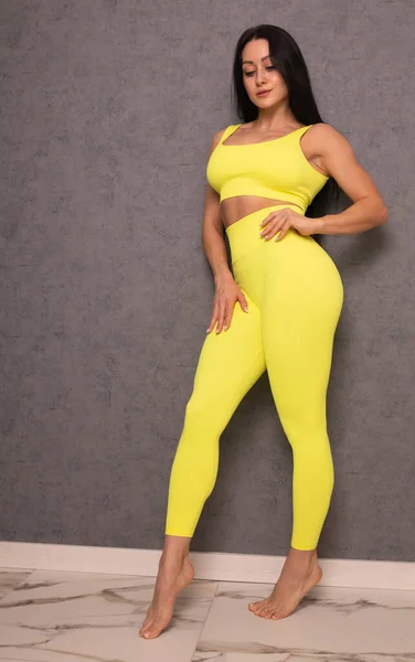 Bela Jovem Morena Sportswear Amarelo Posando Fundo Cinza — Fotografia de Stock