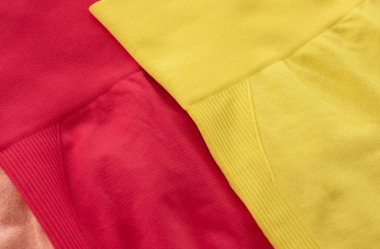 Gri arka planda parlak renkli spor taytlarının yakın plan görüntüsü. Fitness için kıyafet seti