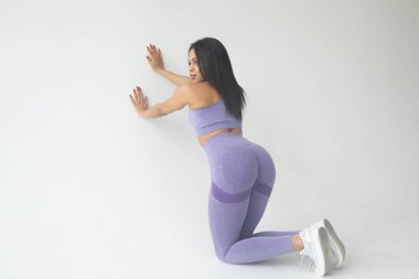 Gri arka planda poz veren mor spor giysili Afro-Amerikan kadının arka plan görüntüsü.  