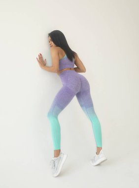 Gri arka planda spor giyimli Afro-Amerikan kadın pozu