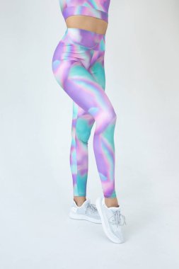 Gri arka planda renkli spor kıyafetleri giymiş Afro-Amerikan kadınlarının düşük kesimi