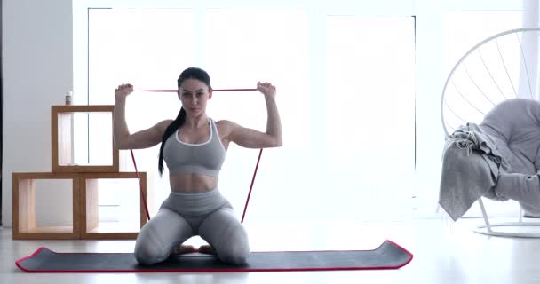运动适合在室内用弹性带进行锻炼的年轻女子 家庭健康和健康概念 — 图库视频影像