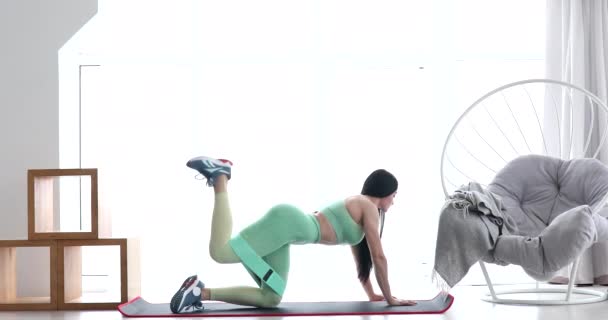 Atletyczna Dziewczyna Robi Ćwiczenia Fitness Aerobik Trening Elastyczną Opaską Salonie — Wideo stockowe