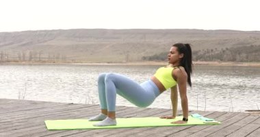 Sportif güçlü Afrikalı Amerikalı kız doğa eğitimi alıyor. Aktif fitness genç kadın karın kasları çalıştırıyor