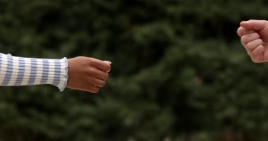 Beyaz bir erkek ve Afrikalı bir kadının gizli el sıkışması. Değişik bir selamlama şekli. Irkçılık ve arkadaşlık kavramı yok..