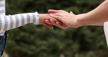 Bir erkekle kadının el ele tutuşması. 