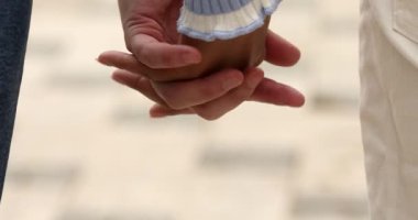 Birbirine aşık genç çiftin el ele tutuşup birlikte yürüdüğü yakın plan görüntüler.