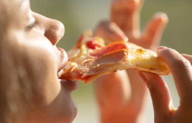 woman eating pizza with ham and cheese 