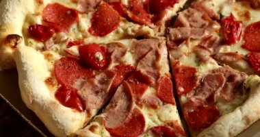 Jambonlu, peynirli ve salamlı lezzetli bir pizza. 