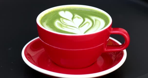 Red Cup Coffee Green Latte Art Black Table Top View — Video Stock