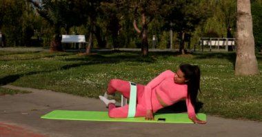 Yoga yapan genç bir kadın ya da parkta yeşil çimlere uzanan bir kadın.. 