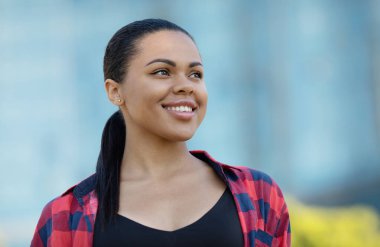 Gülümseyen güzel siyah bir kadının portresi. Güzel Afro-Amerikan genç bir kadının açık hava portresi. 