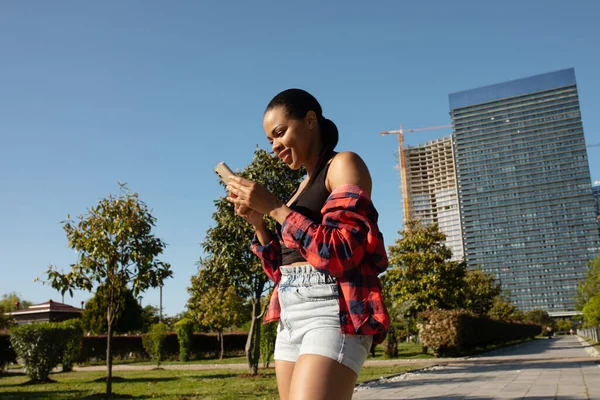 Güzel Afro Amerikalı Bir Kadın Elinde Akıllı Bir Telefonla Parkta — Stok fotoğraf