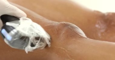 Bir güzellik salonundaki kanepede uzanmış ince bacaklarda lazer tüyü temizliği yapan siyahi kadın. Kozmetik, epilasyon ve spa konsepti. Vücut bakımı. Saç çıkarma prosedürü.