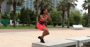 Batumi, Georgia - 13 Haziran 2022: Genç gülümseyen fitness kadını sahilde spor yapıyor. Spor salonu açık havada. Çekici fit siyah kadın. Açık havada egzersiz. Sağlıklı yaşam tarzı.