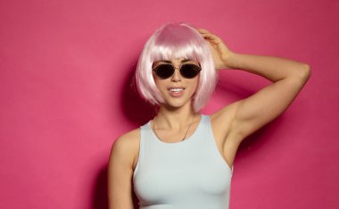 Pembe arka planda pembe saçlı güzel ve seksi bir kadın.