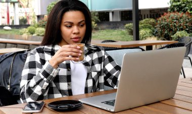 Açık kafede dinlendirici ve bir dizüstü bilgisayar kullanarak bir mutlu genç Afrikalı kadın portresi