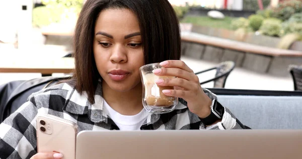 young woman with cup of coffee and laptop in cafe