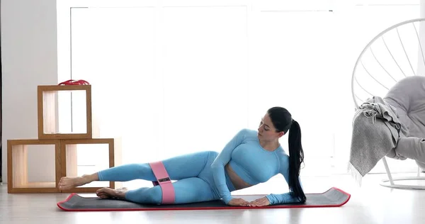 Spor Kıyafetli Genç Bir Kadın Oturma Odasında Elastik Bantla Spor — Stok fotoğraf