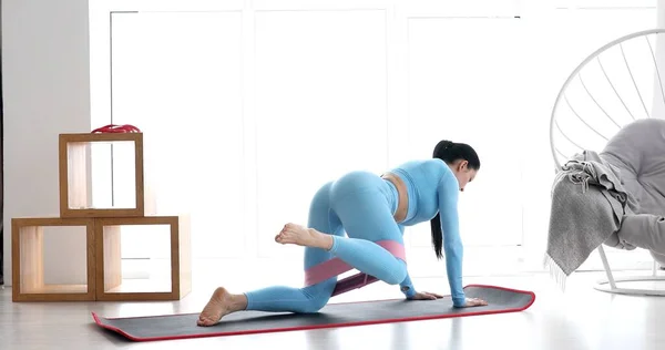 Spor Kıyafetli Genç Bir Kadın Oturma Odasında Elastik Bantla Spor — Stok fotoğraf