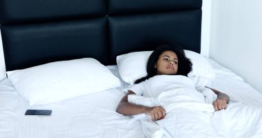 Yatak odasında akıllı telefonu olan güzel kız.