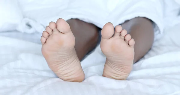 close up of a female feet on a bed