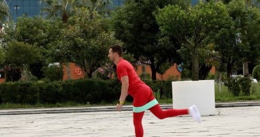 young man training with elastic band outdoors