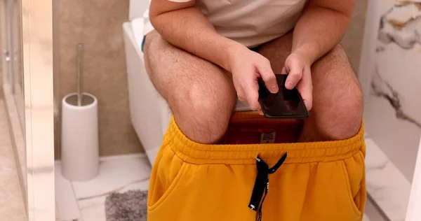 Man Zit Het Toilet Kijkt Naar Mobiele Telefoon Thuis — Stockfoto