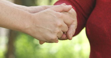 close up of young and senior people holding hands together