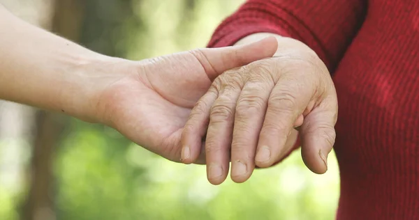 close up of young and senior people holding hands together