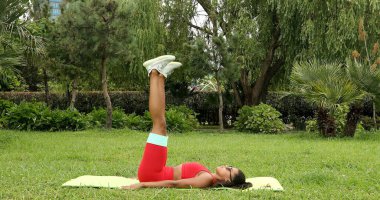 Genç bir kadın spor giyim reyonunda direniş gruplarıyla çalışıyor. Lastik spor kemeri olan bir spor eğitmeni.