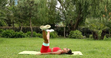 Genç bir kadın spor giyim reyonunda direniş gruplarıyla çalışıyor. Lastik spor kemeri olan bir spor eğitmeni.