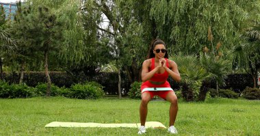 Genç bir kadın spor giyim reyonunda direniş gruplarıyla çalışıyor. Lastik spor kemeri olan bir spor eğitmeni.