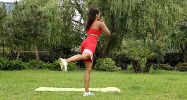 Genç bir kadın spor giyim reyonunda direniş gruplarıyla çalışıyor. Lastik spor kemeri olan bir spor eğitmeni.