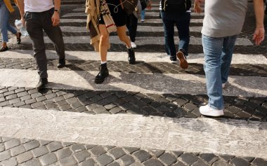 Roma, İtalya - 12 Ekim 2022. Zebra geçiyor. Kalabalık bir yaya sürüsü caddeden karşıya geçiyor..