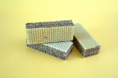 Sarı arka planda kahverengi dolgulu üç waffle.